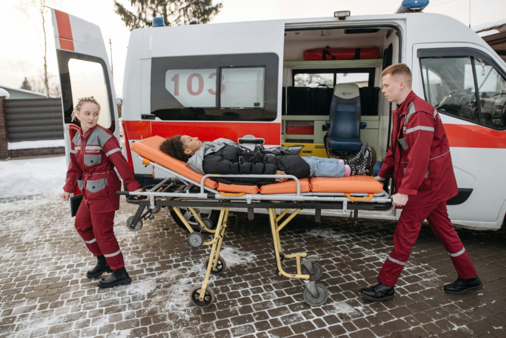 Paramedics transport a patient on a stretcher to an ambulance, showcasing emergency medical response.